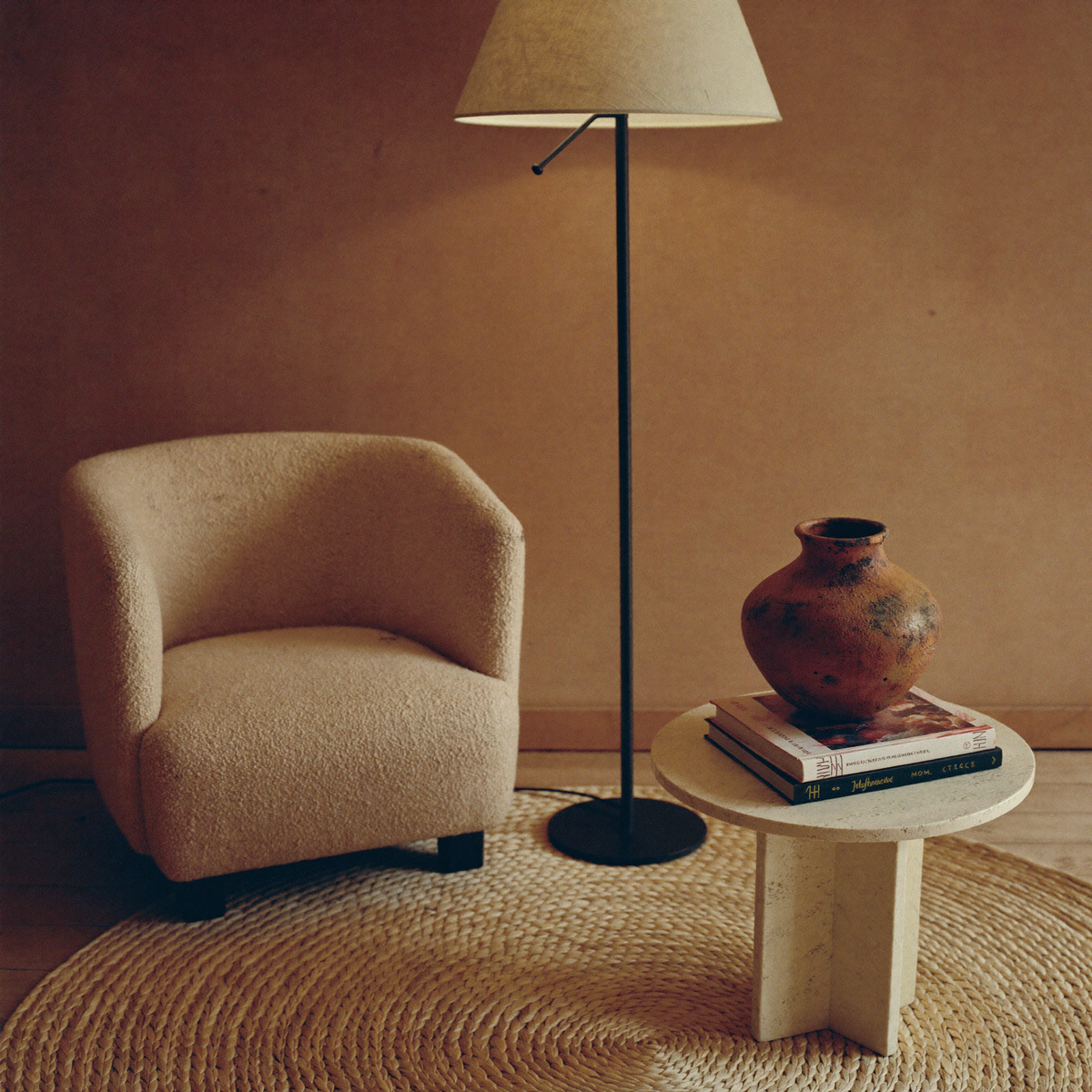 Home Interior — bouclé armchair, floor lamp and ceramic vase in warm daylight